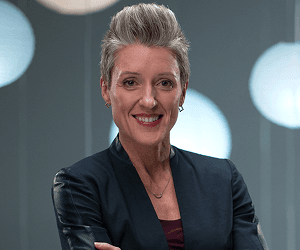 A headshot of Jenny wearing a suit jacket.